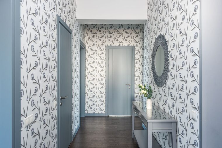 Hallway lined with delicate floral wallpaper and a console table