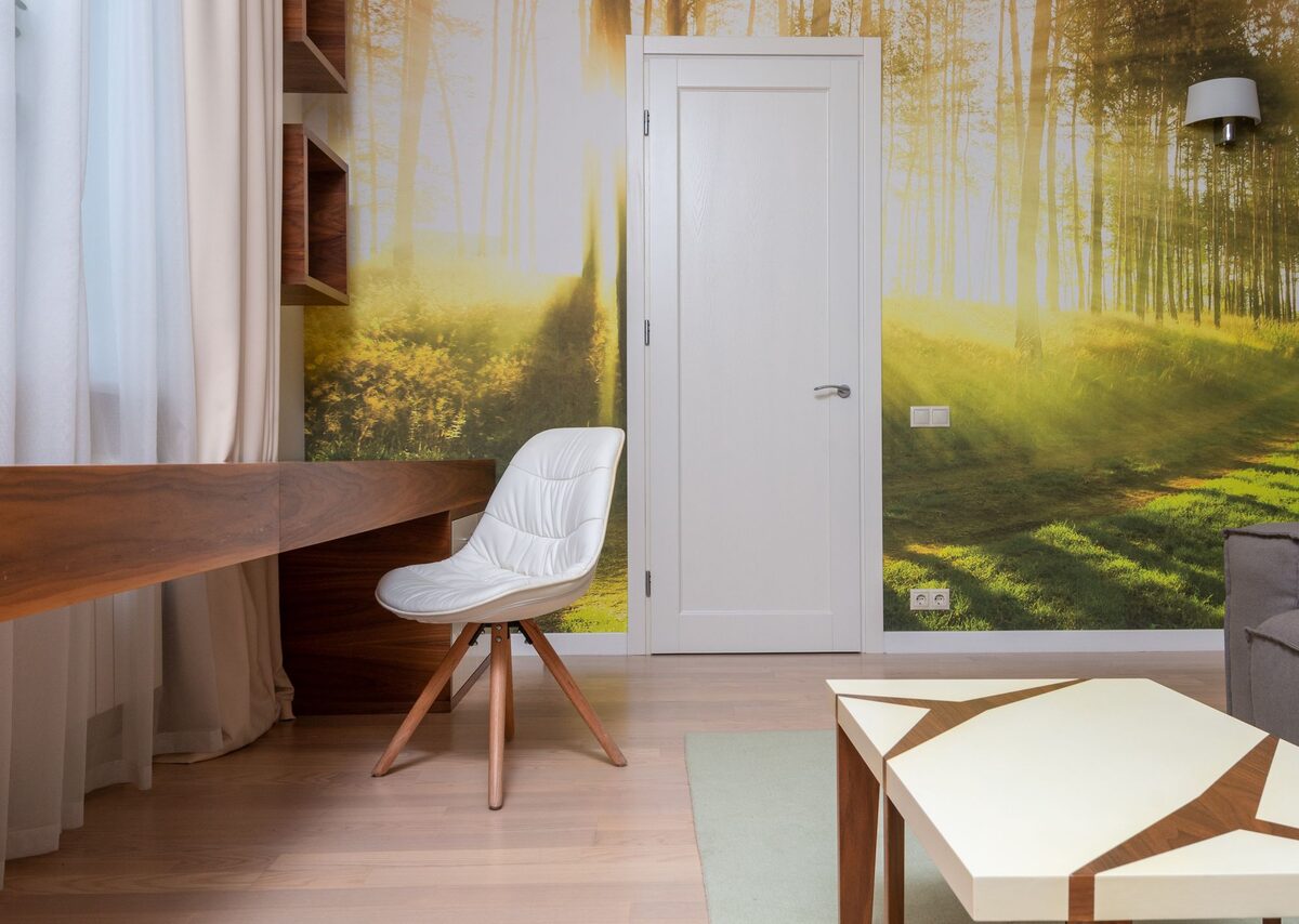 Study nook with a forest-mural wallpaper behind a writing desk